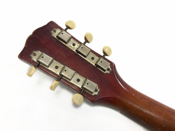 Vintage acoustic guitar headstock with six cream tuning pegs and metal tuning machines on a reddish-brown wood neck against a white background