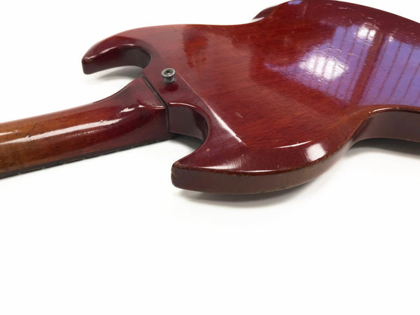 Close-up of the back and neck joint of a vintage red electric guitar showing wood grain and finish wear, isolated on white background