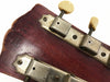 Close-up of vintage guitar headstock with aged tuning pegs and visible serial number stamped on worn wood finish