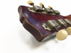 Close-up of worn vintage guitar headstock with aged tuning pegs and cream-colored tuning keys against white background