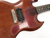 Close-up of vintage worn cherry red electric guitar body with single black pickup and silver bridge by Coffee House Guitars