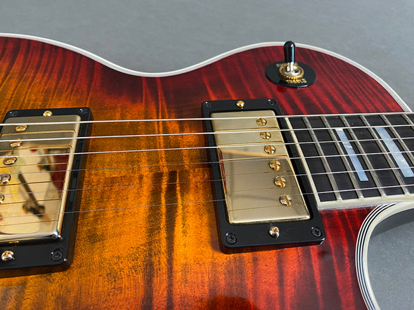 Close-up of sunburst electric guitar body showing gold humbucker pickups, toggle switch, and strings on Coffee House Guitars product listing