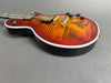Electric guitar with sunburst finish and gold hardware on gray background