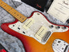 Fender electric guitar with sunburst finish, maple neck, pearl white pickguard, and dual Fender pickups displayed on grey fur padding with Fender certificate of authenticity and branded pouch.