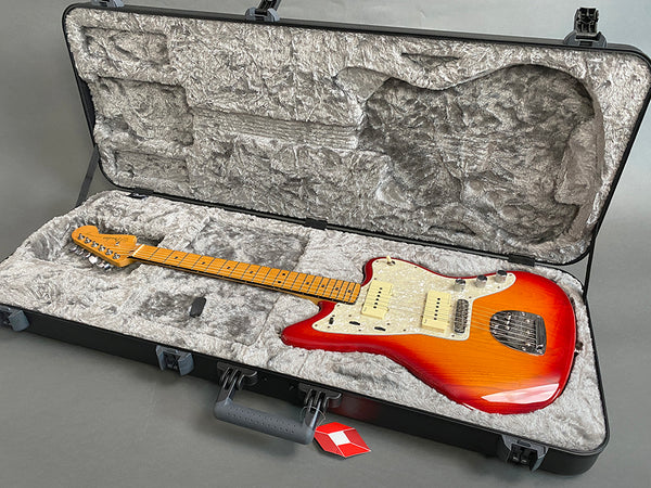 Fender electric guitar with sunburst finish and maple neck in plush lined hard case on grey background
