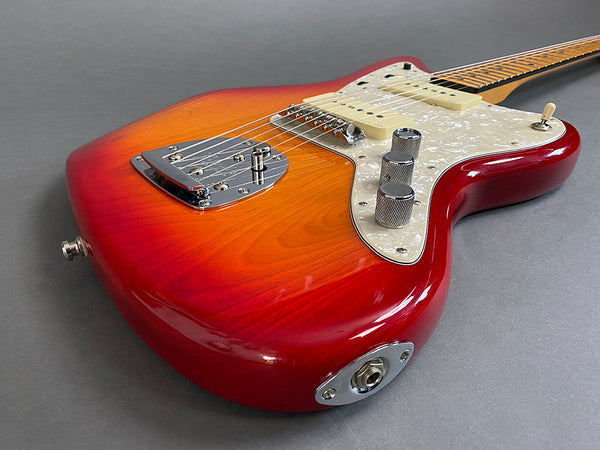 Electric guitar with sunburst finish, pearl white pickguard, chrome hardware, and maple neck on gray background