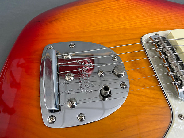Close-up of Fender electric guitar bridge and tailpiece on sunburst finish body with chrome hardware and strings