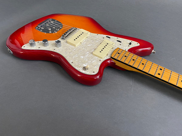 Electric guitar with sunburst finish, white pearloid pickguard, maple neck, and dual single-coil pickups on gray background