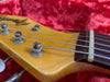 Close-up of vintage electric guitar headstock with tuning pegs, metal strings, and nut on wood fretboard, resting on red plush fabric background