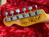 Fender Custom Shop guitar headstock with vintage tuning pegs on red plush case interior, signed by artist