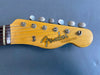 Close-up of vintage Fender Telecaster guitar headstock with six tuning pegs on blue background