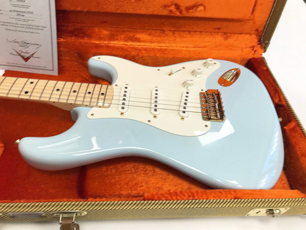 Light blue electric guitar with maple neck and white pickguard in orange lined guitar case