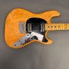 Vintage natural wood electric guitar with black pickguard, dual humbucker pickups, chrome control plate, and maple fretboard on gray background