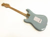 Back view of light blue electric guitar with maple neck and gold hardware on white background, showing body contours and rear cavity plate.