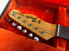 Close-up of vintage Fender Telecaster guitar headstock with tuning pegs inside orange velvet guitar case