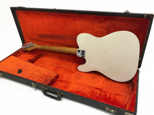 Electric guitar with light wood finish shown from back in vintage black hard case with orange plush interior lining