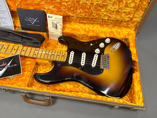 Vintage Fender Stratocaster electric guitar in sunburst finish with maple neck and black pickguard in orange plush-lined hard case with Fender Custom Care documentation and black guitar strap