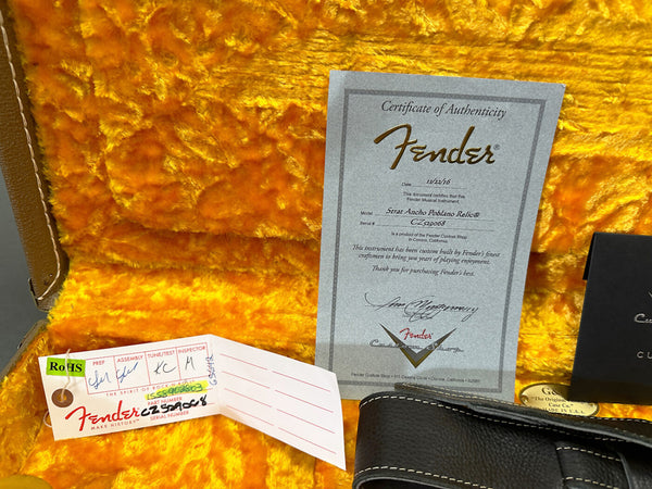 Fender Certificate of Authenticity for Strat Ancho Poblano Relic guitar inside a yellow plush guitar case with Fender tags and case strap.