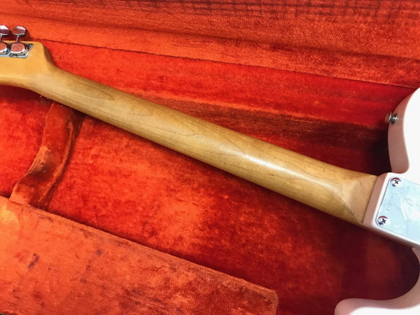 Close-up of maple neck and tuning pegs on electric guitar in red velvet guitar case interior