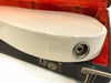 Close-up of white electric guitar body with visible wear and scratch near output jack, resting on vintage orange-lined guitar case