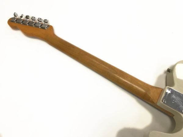 Back view of maple neck and chrome tuning pegs on white electric guitar showing neck plate with serial number and Fender logo