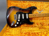 Vintage sunburst Fender Stratocaster electric guitar with maple neck and black pickguard in yellow plush Fender case
