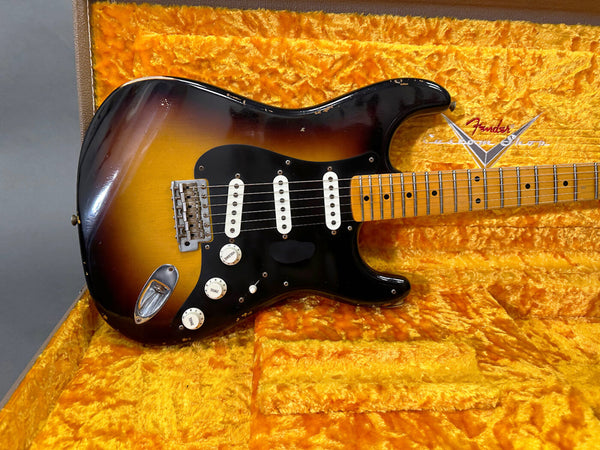 Vintage sunburst Fender Stratocaster electric guitar with maple neck and black pickguard in yellow plush Fender case