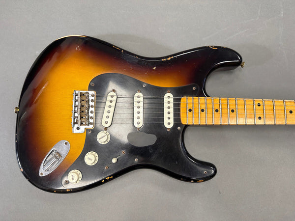 Vintage sunburst electric guitar with three single-coil pickups and maple fretboard showing signs of wear and aging