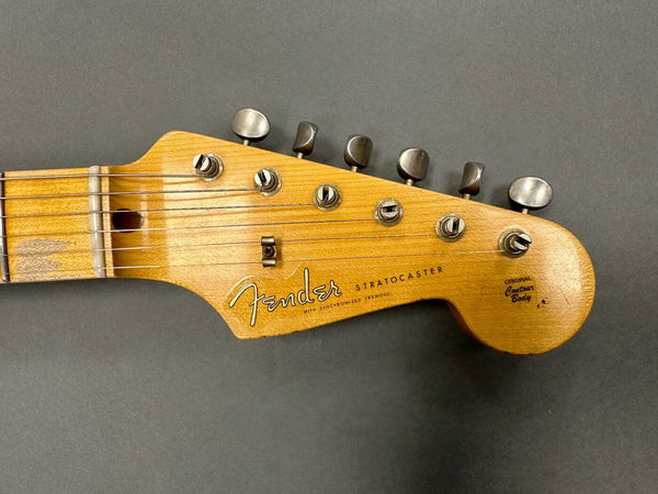 Fender Stratocaster guitar headstock with vintage tuners and original contour body decal on gray background