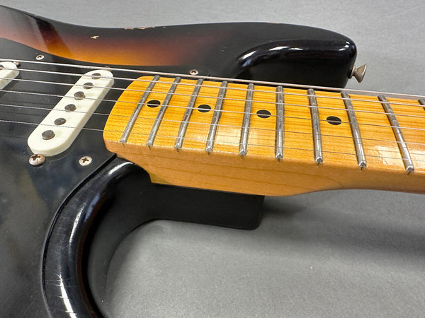 Close-up of vintage electric guitar maple neck and fretboard with six strings and single-coil pickup on sunburst body