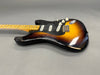 Vintage sunburst electric guitar with maple neck and black pickguard, showing wear and aging on the body and hardware
