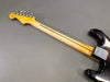 Vintage Fender Stratocaster electric guitar back view showing maple neck with skunk stripe and tuning pegs on headstock against gray background