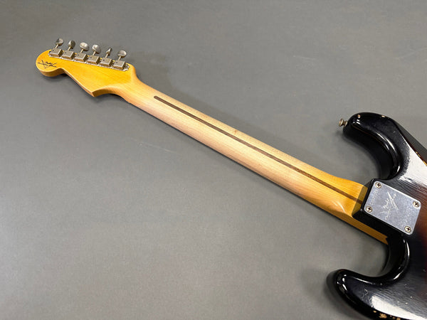 Vintage Fender Stratocaster electric guitar back view showing maple neck with skunk stripe and tuning pegs on headstock against gray background