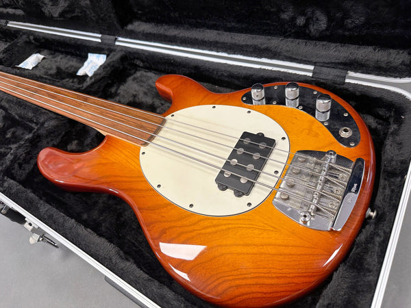 Electric bass guitar with sunburst finish, four strings, single pickup, and chrome hardware in a black plush-lined hard case