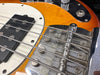 Close-up of electric bass guitar bridge, strings, and pickup on sunburst finish body at Coffee House Guitars