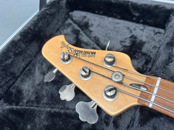 Ernie Ball Music Man StingRay bass guitar headstock with tuning pegs inside black plush guitar case