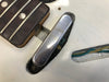 Close-up of vintage electric guitar toggle switch and part of rosewood fretboard with metal frets on white guitar body showing wiring cavity