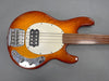 Vintage orange sunburst electric bass guitar with chrome hardware and white pickguard on gray background