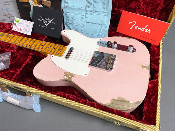 Fender Custom Shop pink relic Telecaster electric guitar with maple neck and white pickguard in a tweed hardshell case with red plush interior, Fender owner's manual, Custom Care booklet, and certificate of authenticity.