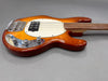 Sunburst finish electric bass guitar with chrome hardware and white pickguard on gray background