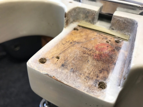 Close-up of the neck pocket cavity on a vintage or used electric guitar body showing worn wood and screw holes for neck attachment.