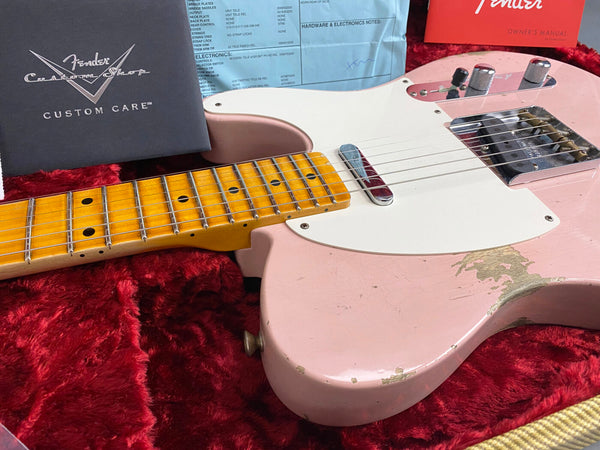 Vintage Fender Custom Shop Telecaster guitar in pink with maple neck, showing wear and finish relic, displayed in red plush case with Fender Custom Shop Custom Care booklet and owner's manual.