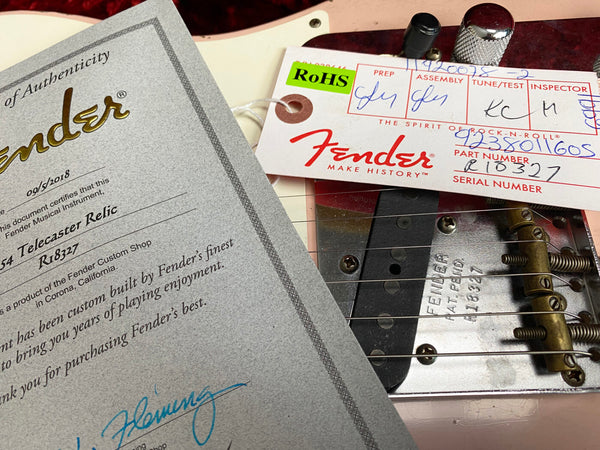 Close-up of Fender Custom Shop certificate of authenticity and Fender tag on 1954 Telecaster Relic electric guitar with serial number R18327 and part number R10327, featuring vintage-style bridge and strings