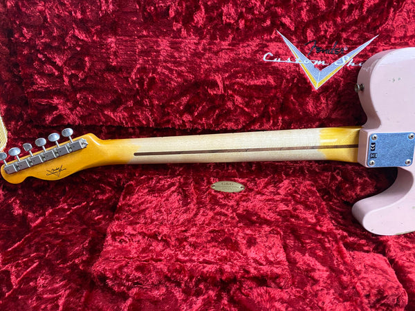 Back view of Fender Custom Shop electric guitar neck with six tuning pegs on red velvet guitar case interior