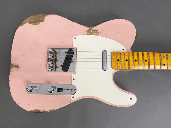 Close-up of worn pink electric guitar body with white pickguard and maple fretboard on gray background