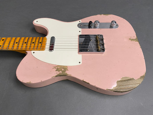 Vintage pink electric guitar with maple neck and white pickguard, showing worn paint and relic finish on gray background