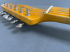 Close-up of vintage Fender Telecaster guitar headstock with tuning pegs and strings on gray background