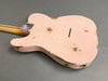 Back of pink relic style electric guitar body with visible wear and metal neck plate on grey background