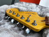 Close-up of Fender Telecaster Deluxe electric guitar headstock with tuning pegs in plush gray guitar case interior