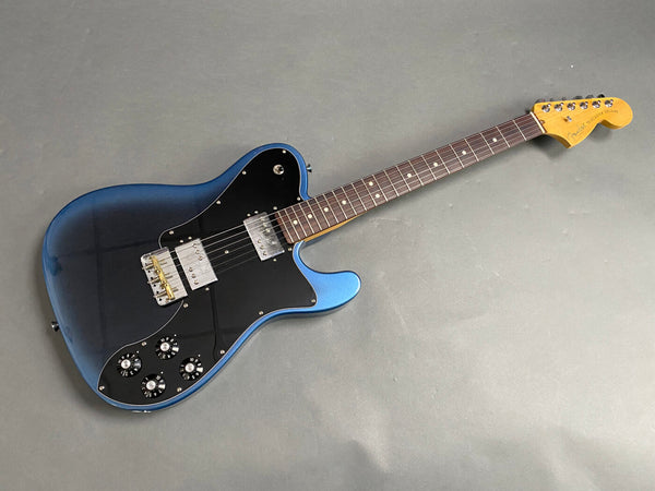 Fender Telecaster Deluxe electric guitar in metallic blue with black pickguard and rosewood fretboard on gray background